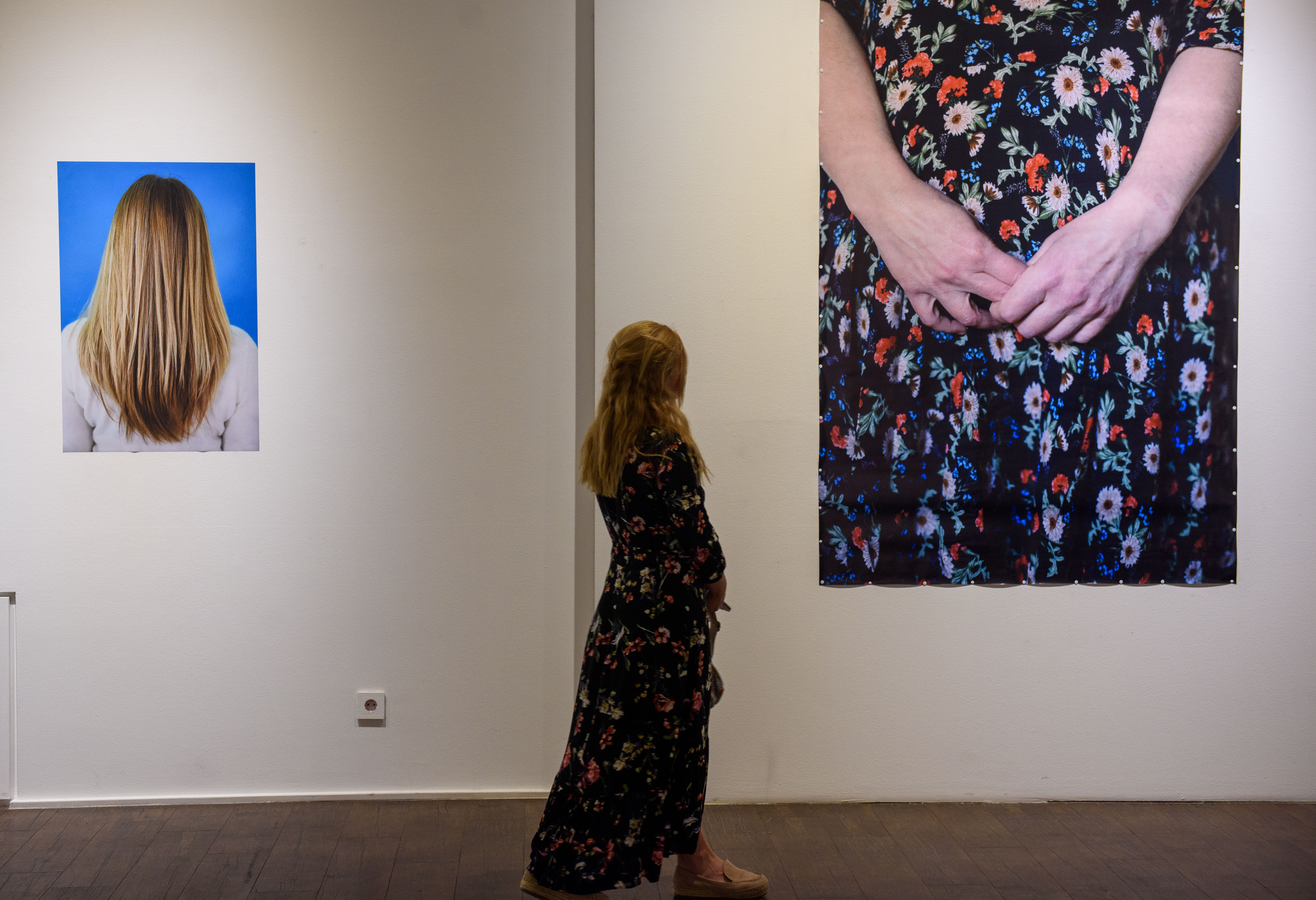 Artist Lia Ukleba watching at her photo wearing the same dress