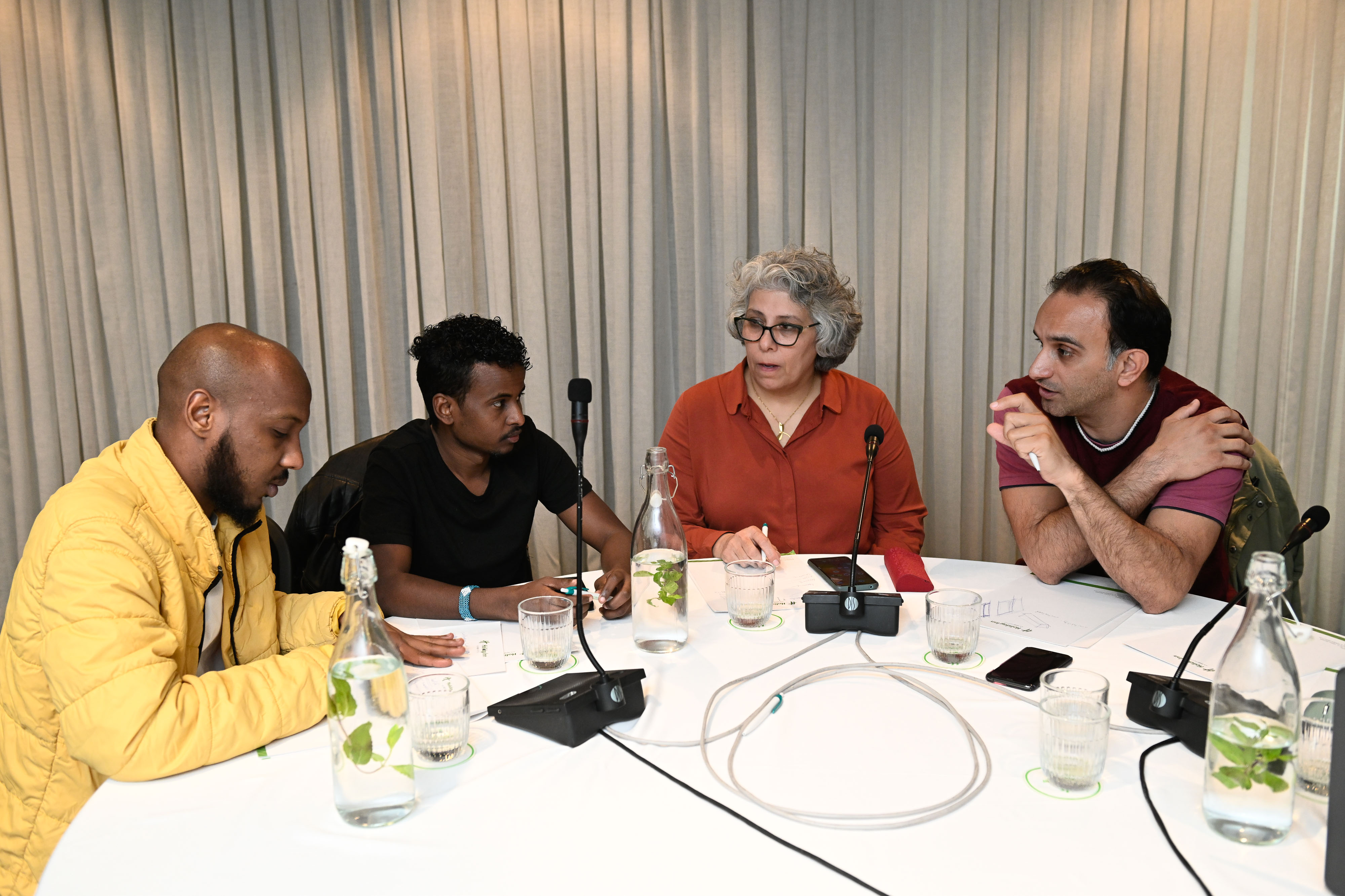 Four people sitting at a roundtable, talking