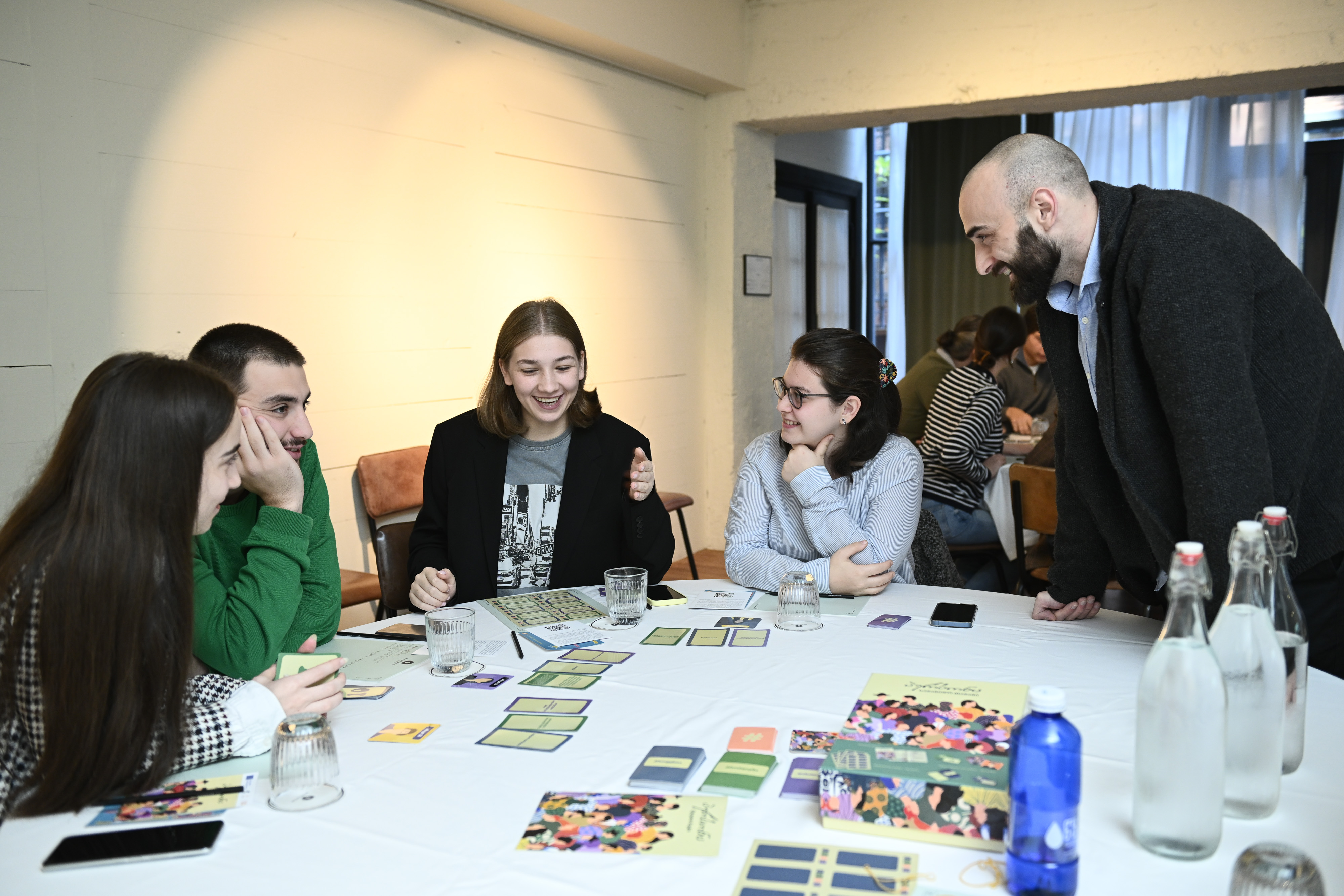 Young people playing a board game called Person