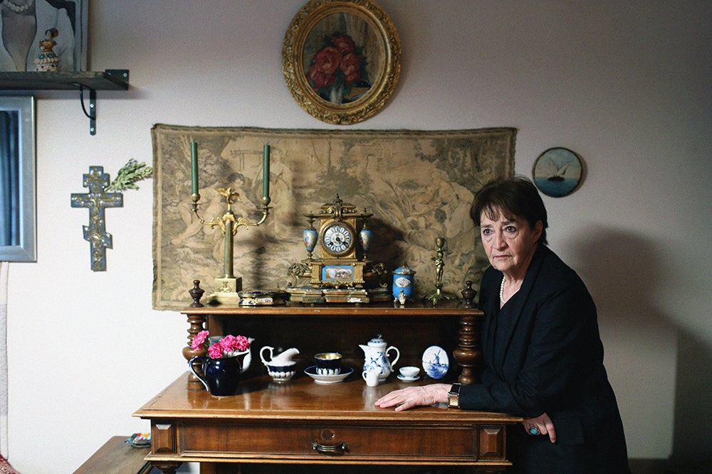 A woman sitting at a table, wearing a black cloth