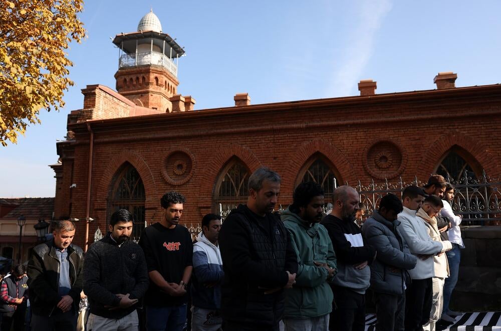 Muslim men standing outside the Mosque, praying