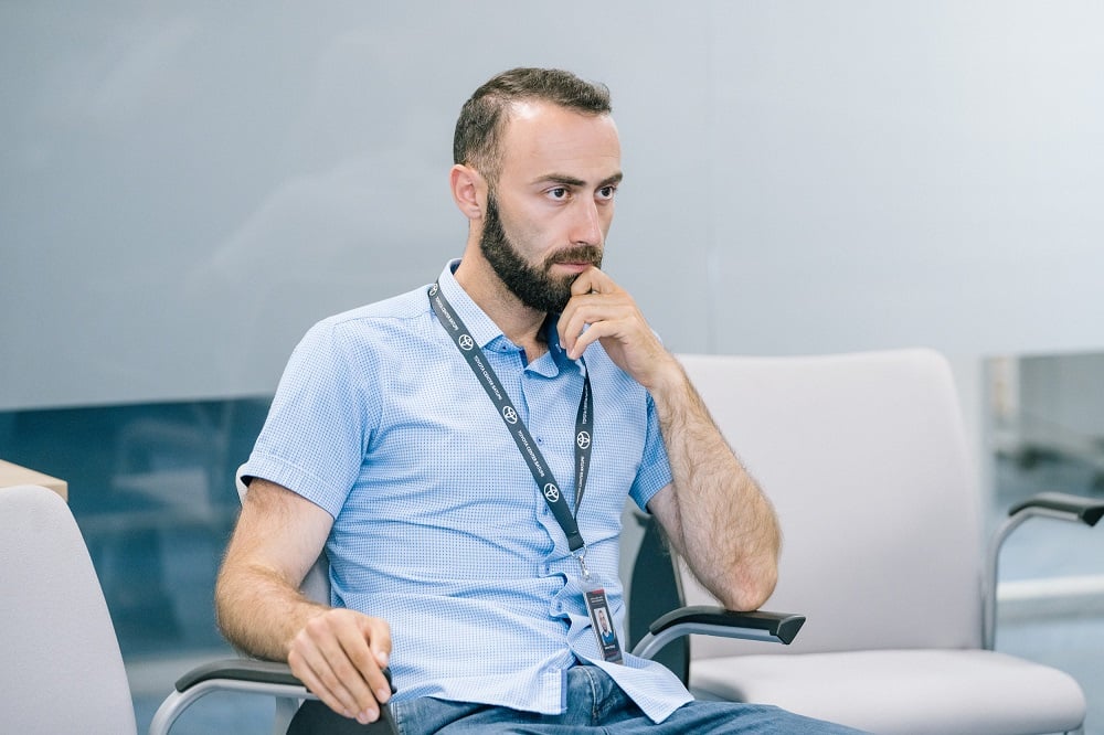 A man, named Kakha Gegidze, is sitting, listening to something