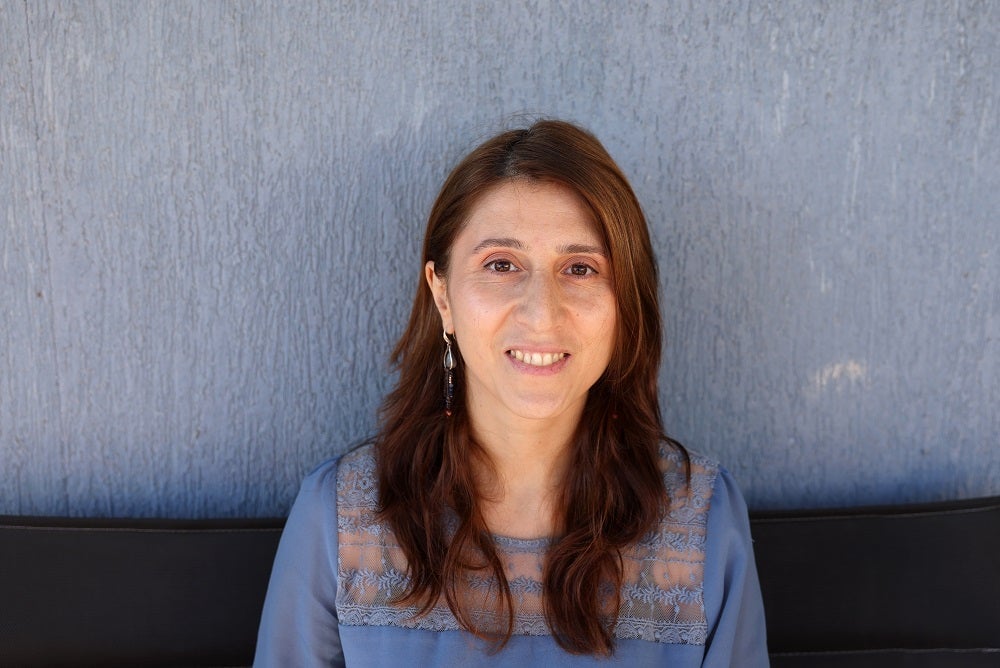 A young woman with long hair is smiling