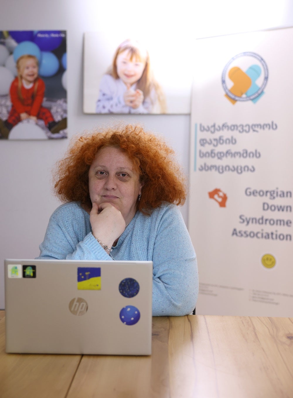 A ginger-hair women is sitting with her computer open