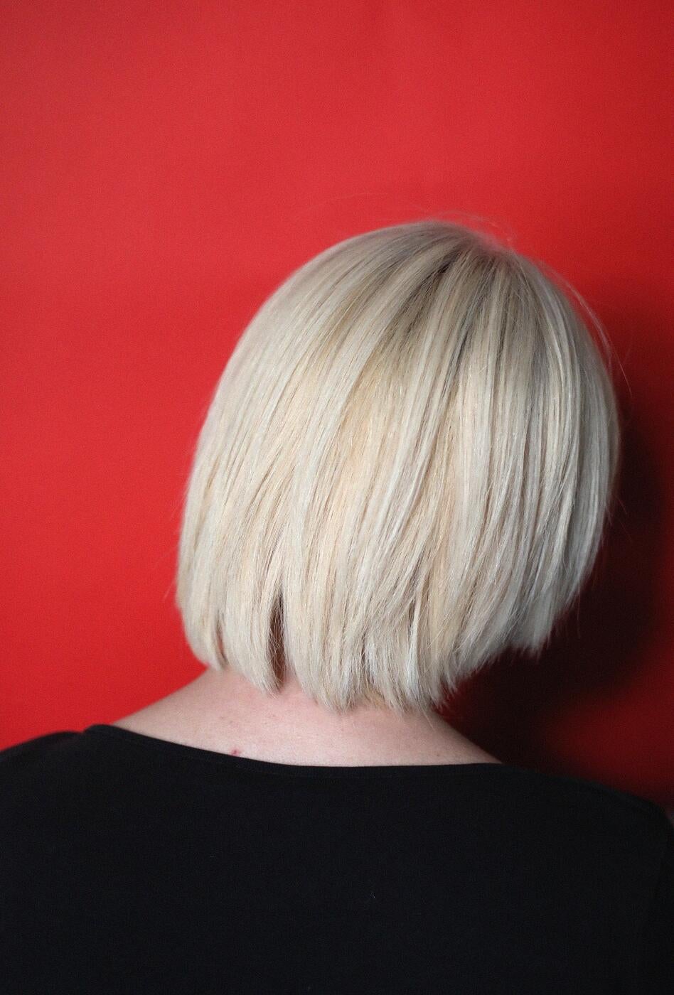 A photo of a blond woman's head from the back