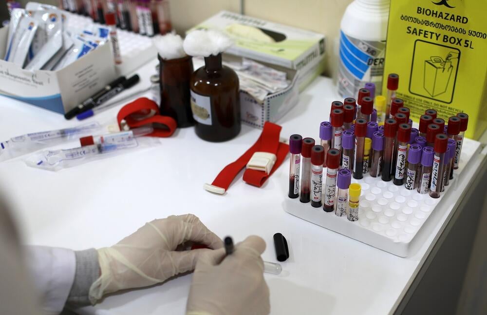 A table full of medical stuff, including biohazard safety boxes with blood testing