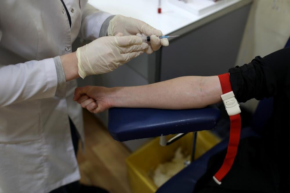 A photo depicting a medical personnel taking blood testing from someone