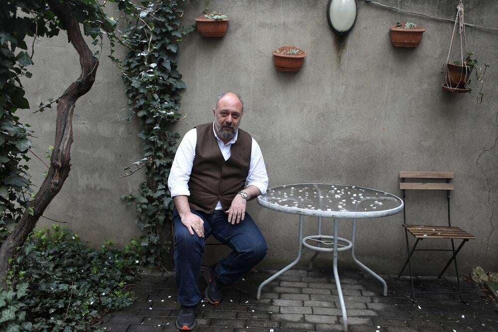 A man sitting at a round table in the yard