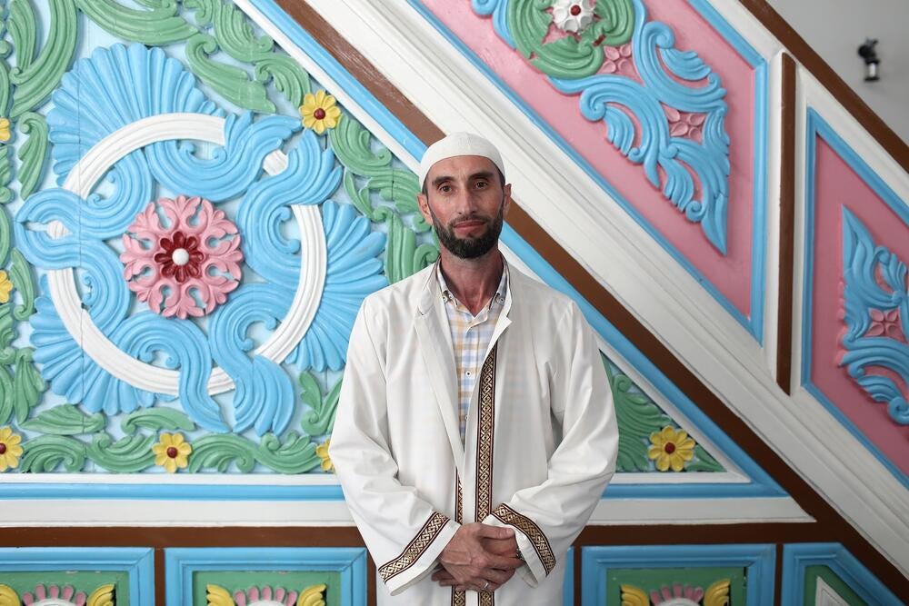 A Deputy Mufti Rezo Mikeladze wearing white clothes and a hat is standing in Batumi Mosque