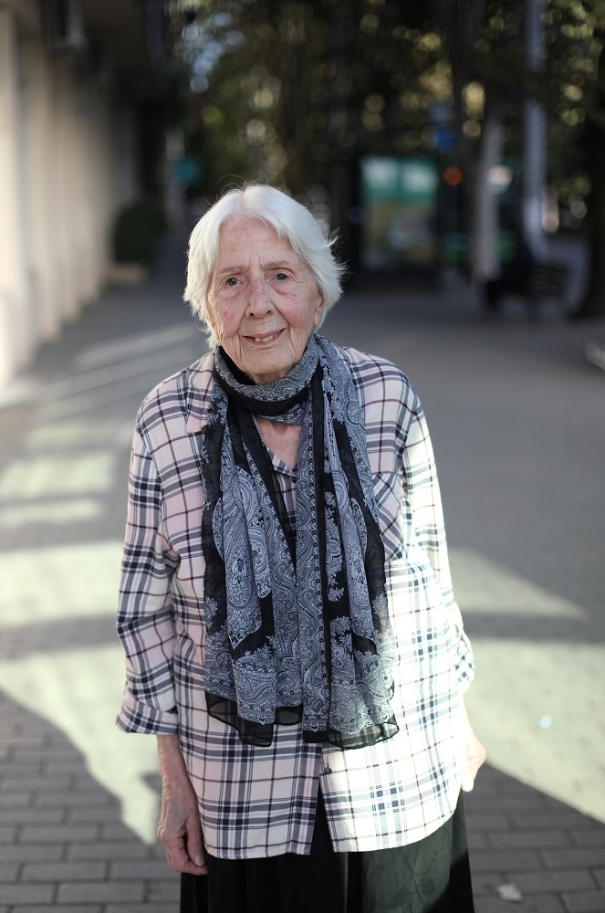 A photo of a woman with gray hair standing outdoor