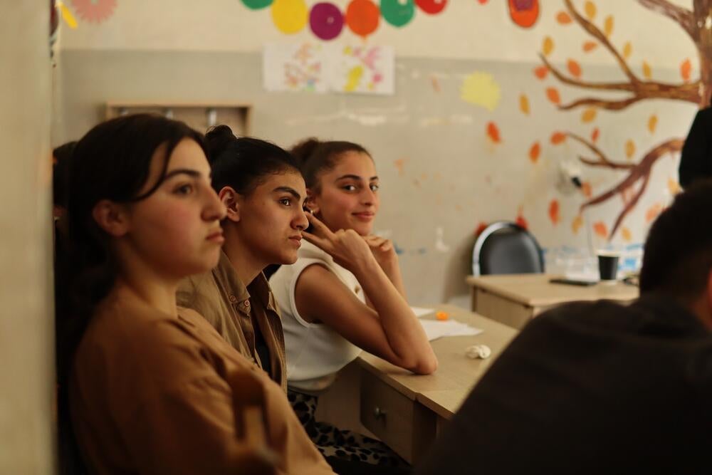 A bunch of adolescents are sitting in a classrom
