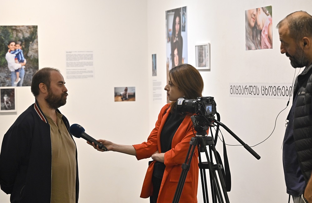 A man is giving an interview to Euronews Georgia crew during a photo exhibition