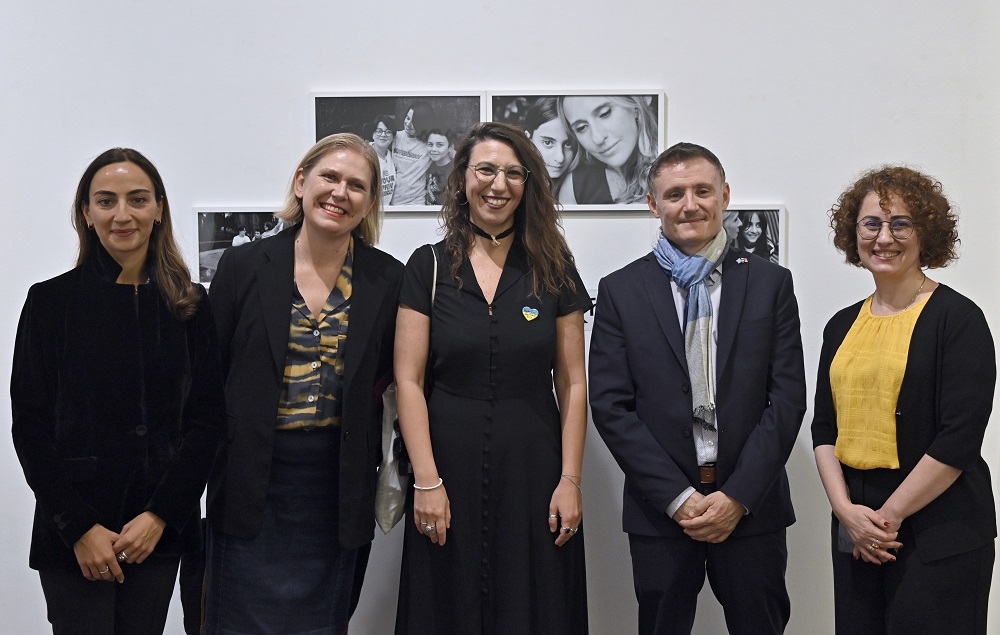 Five people, including one men standing at a wall