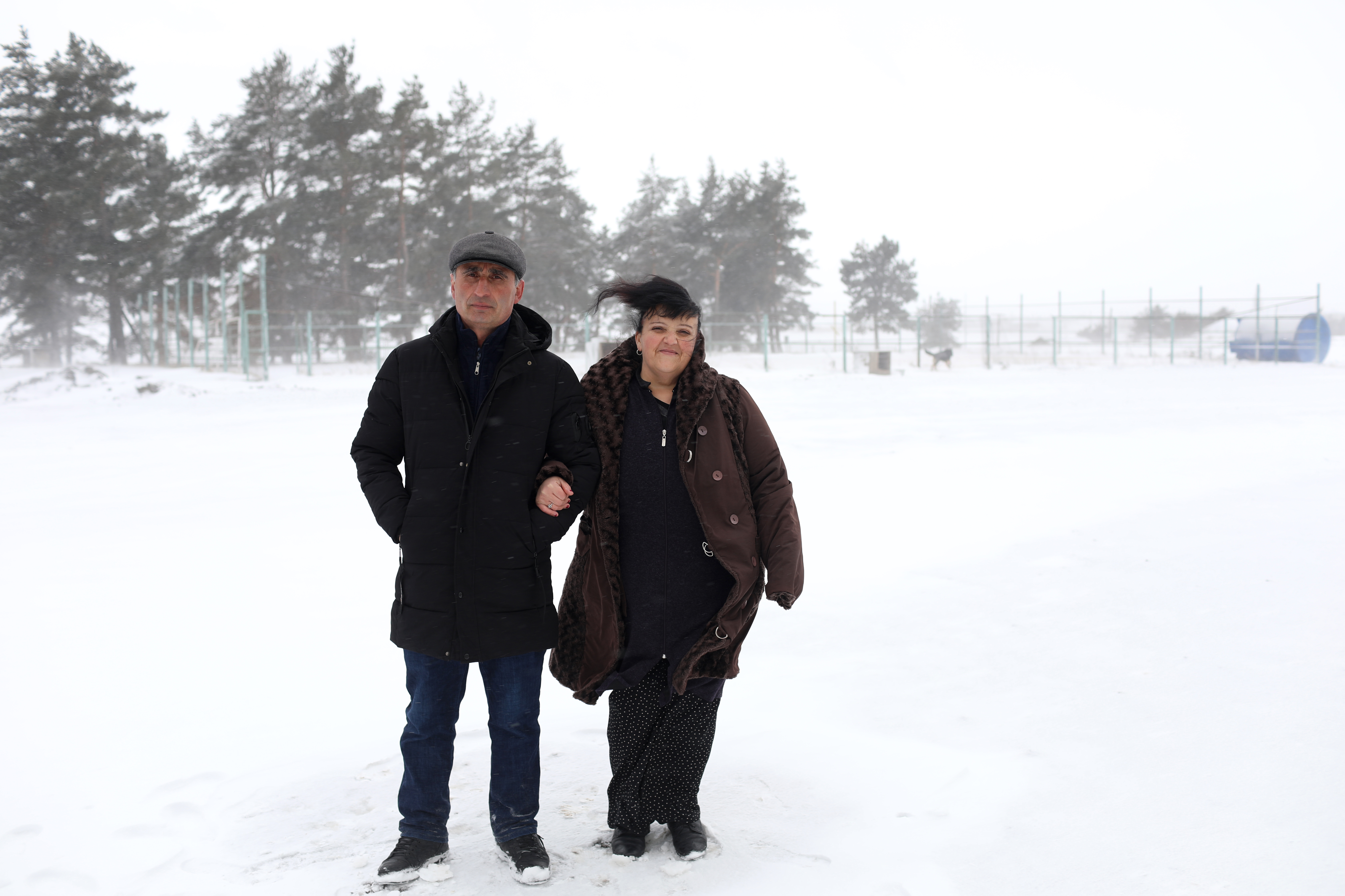 A man and a woman standing in the snow
