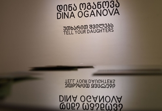 The text on the wall reads Dina Oganova, Tell Your Daughters - the name of the artist and the title of her exhibition