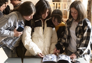 Three adolescent girls reading the comic book