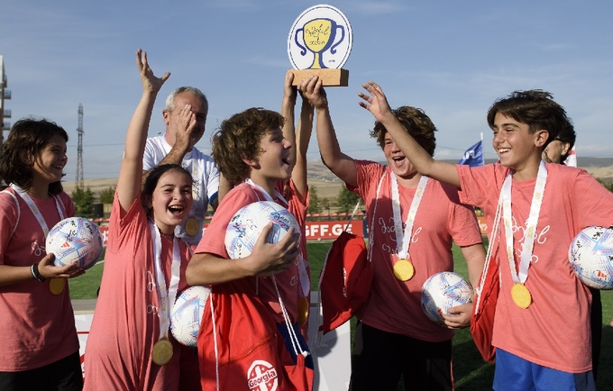 Children holding a trophy after winning a football championship