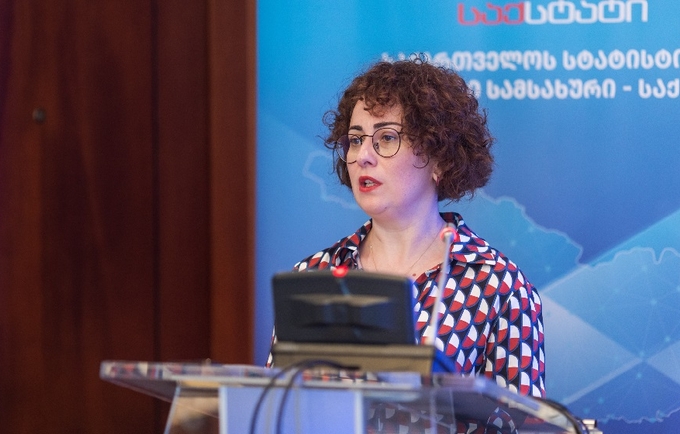 Head of UNFPA Georgia Country Office, Mariam Bandzeladze is standing at a microphone. She has short curly hair and glasses