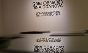 The text on the wall reads Dina Oganova, Tell Your Daughters - the name of the artist and the title of her exhibition
