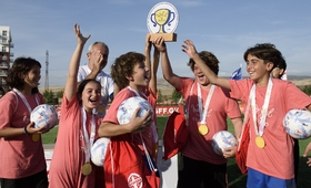 Children holding a trophy after winning a football championship