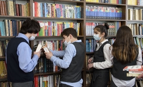 საყუნეთის საჯარო სკოლის მოსწავლე გოგოები და ბიჭები წიგნების თაროს ათვალიერებენ