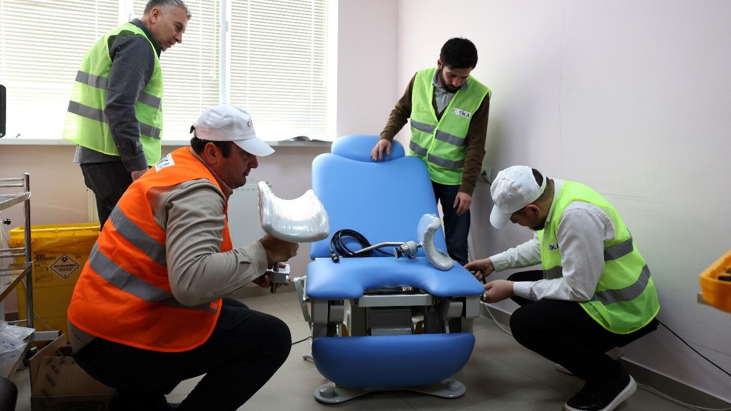 Four men installing accessible chairs at the National Screening Center