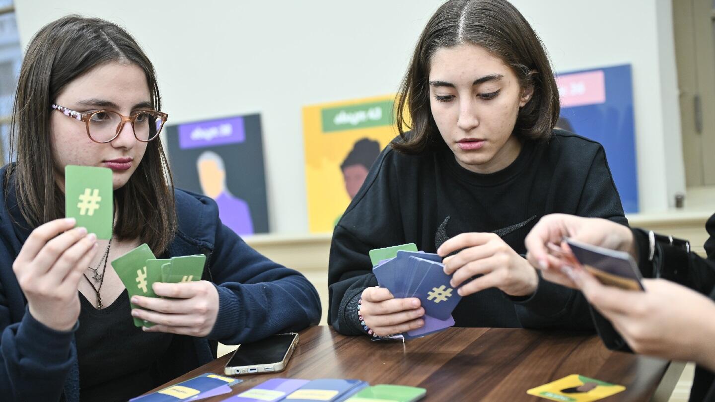 Two adolescent girls playing board game