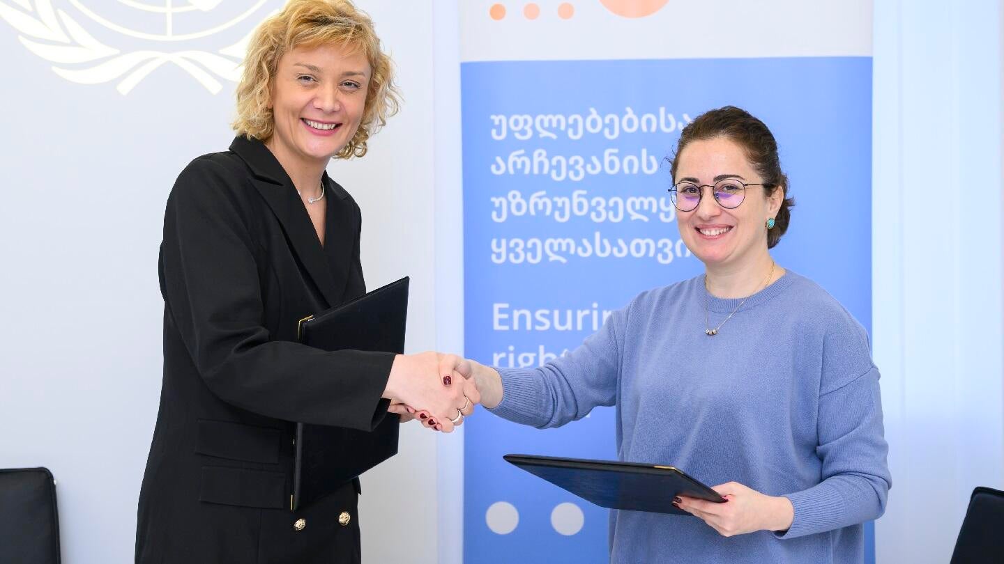 Director of Palitra L Publishing Tina Asatiani and Head of UNFPA Georgia Country Office Mariam Bandzeladze shaking hands, smiling