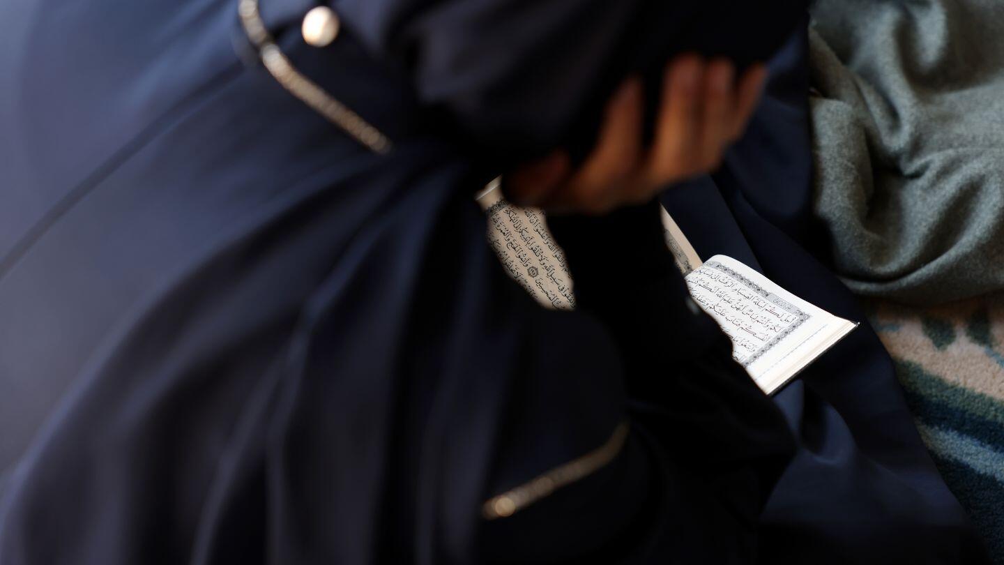 A Muslim woman sitting and reading 
