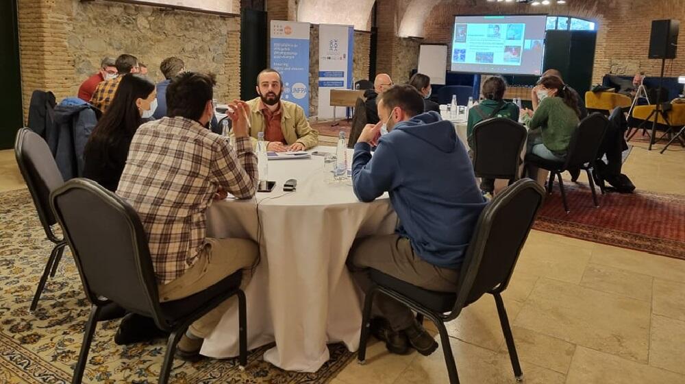 Participants sitting at roundtables 