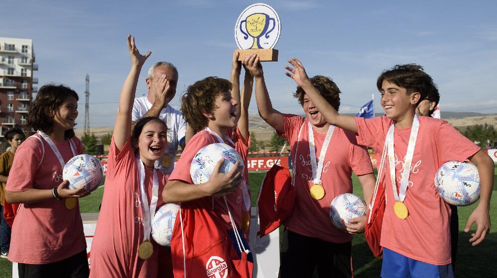 Children holding a trophy after winning a football championship