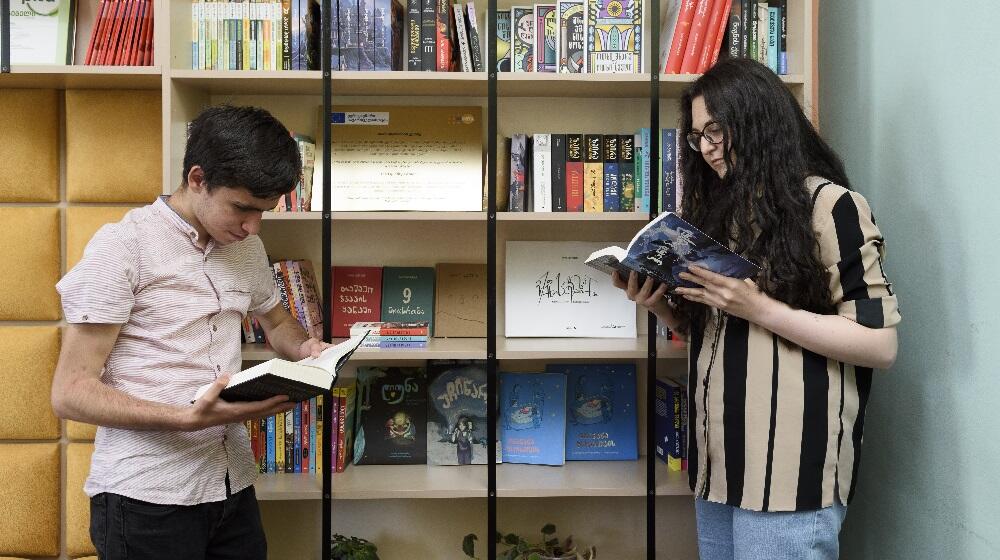 A boy and a girl are reading books