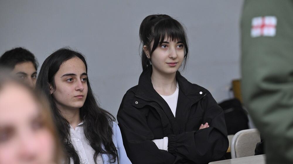 Two adolescent girls sitting at a desk