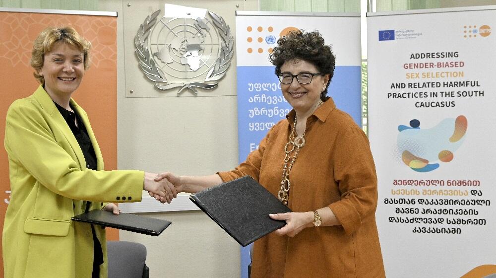 Tinatin Asatiani and Lela Bakradze shaking hands after signing a MoU 