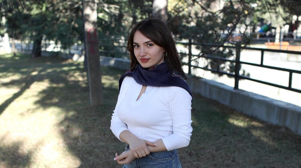 A young woman standing in the middle of a yard