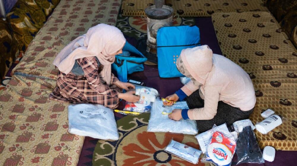 Teenagers Salwa (left) and Kholoud look through the contents of their dignity kits at the AlSekka camp in Idlib, Syria.